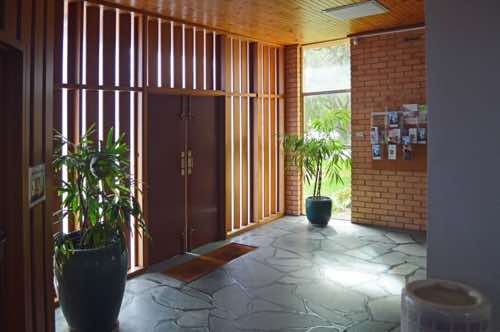 The foyer is roughly L-shaped, and the western leg is similar to the south side, but with some greenery.  A large container of holy water can be seen in the foreground.