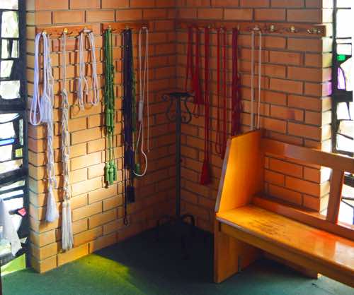 In the corner of the chapel between the windows is a colourful selection of cords, suggesting that this may be used as a robing room by priests and clergy.