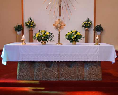 The altar is attractive with its flower arrangements, the central monstrance, and the outer candles.
