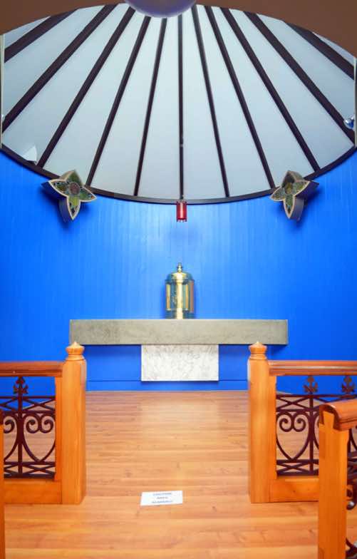 The small circular chapel beneath the window is the Blessed Sacrament Chapel.  Central to this is the Tabernacle, where blessed elements of the Eucharist are kept.
